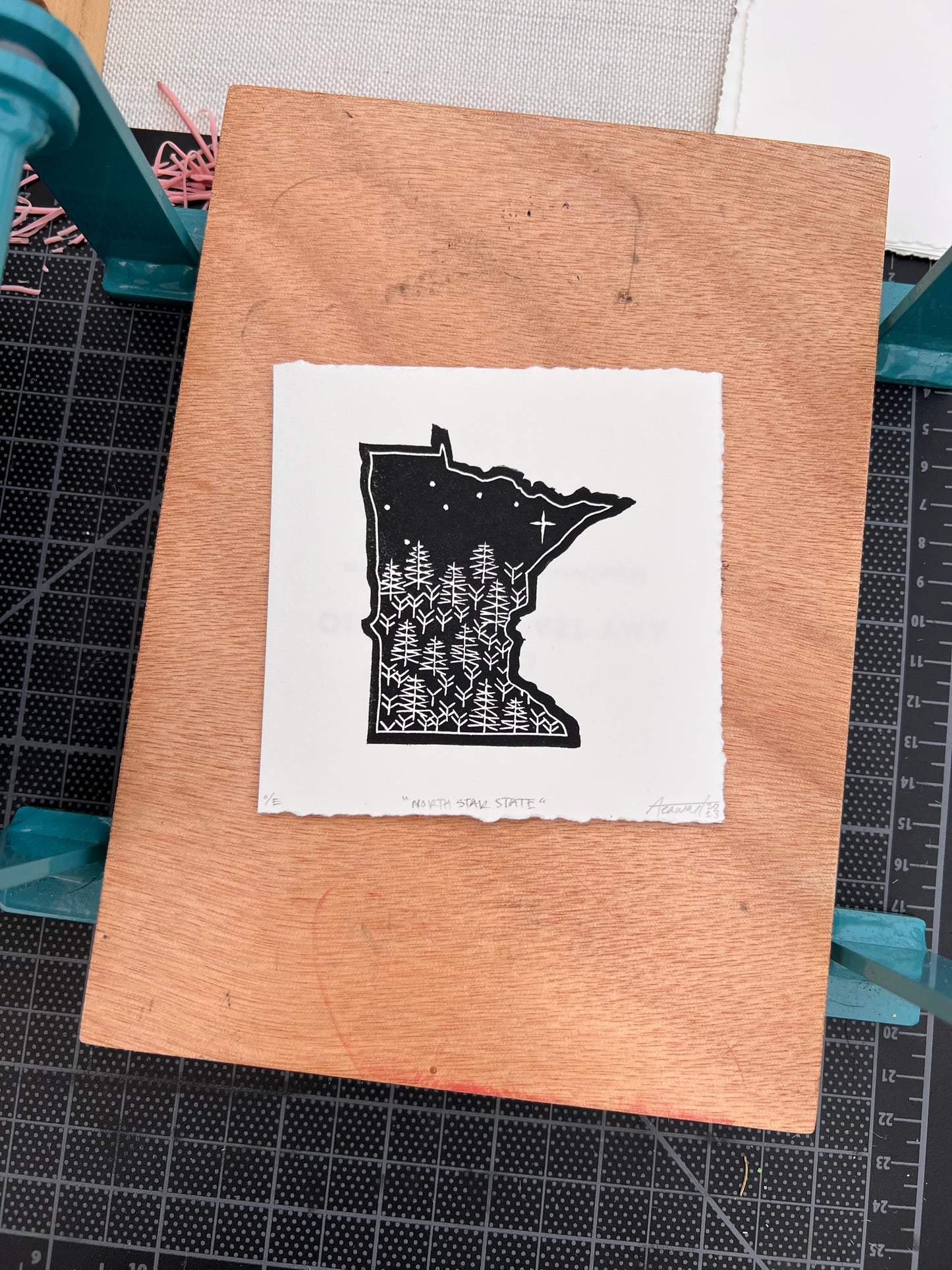 A "North Star State" print sitting on a tabletop press.
